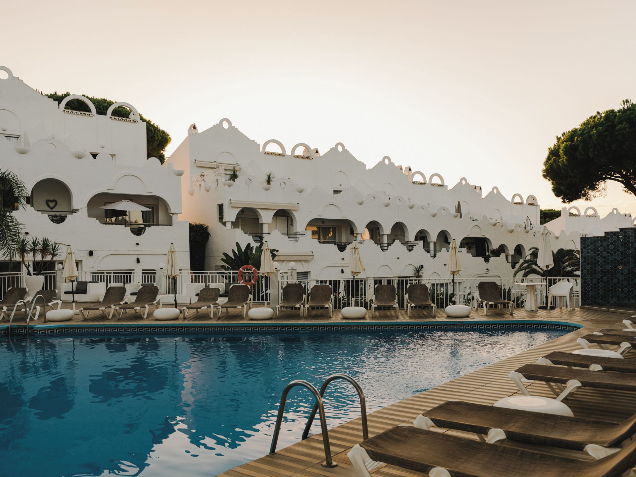 A poolside area with lounge chairs and a swimming pool.