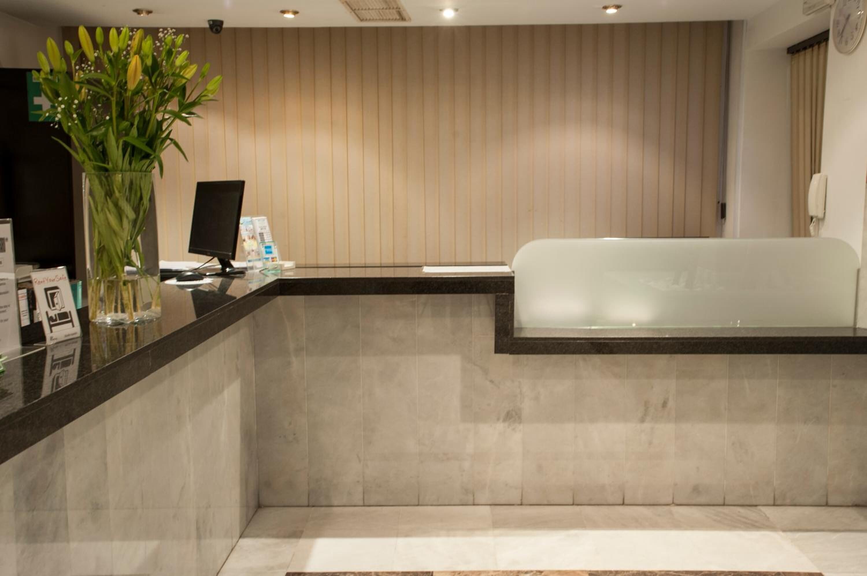 Un espace d’accueil comprenant un comptoir de réception, un ordinateur et une grande baignoire.