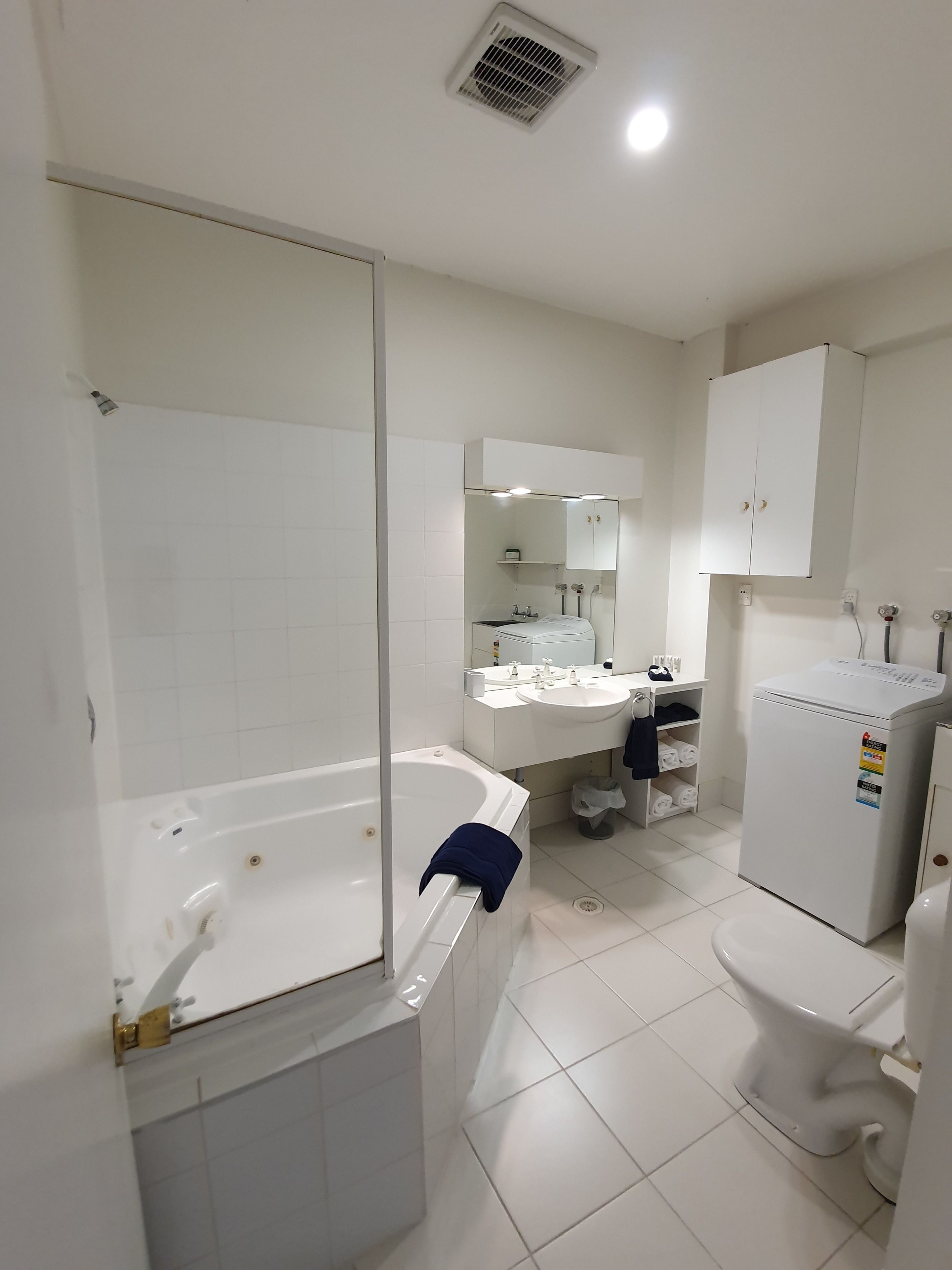 A modern bathroom with a bathtub, a toilet, a sink, and a mirror.