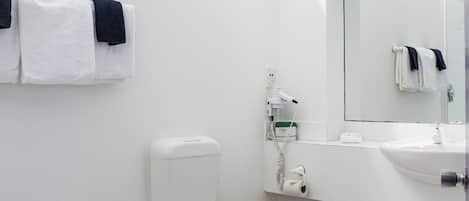 Ein modernes Badezimmer mit Toilette, Waschbecken und Handtuchhalter.