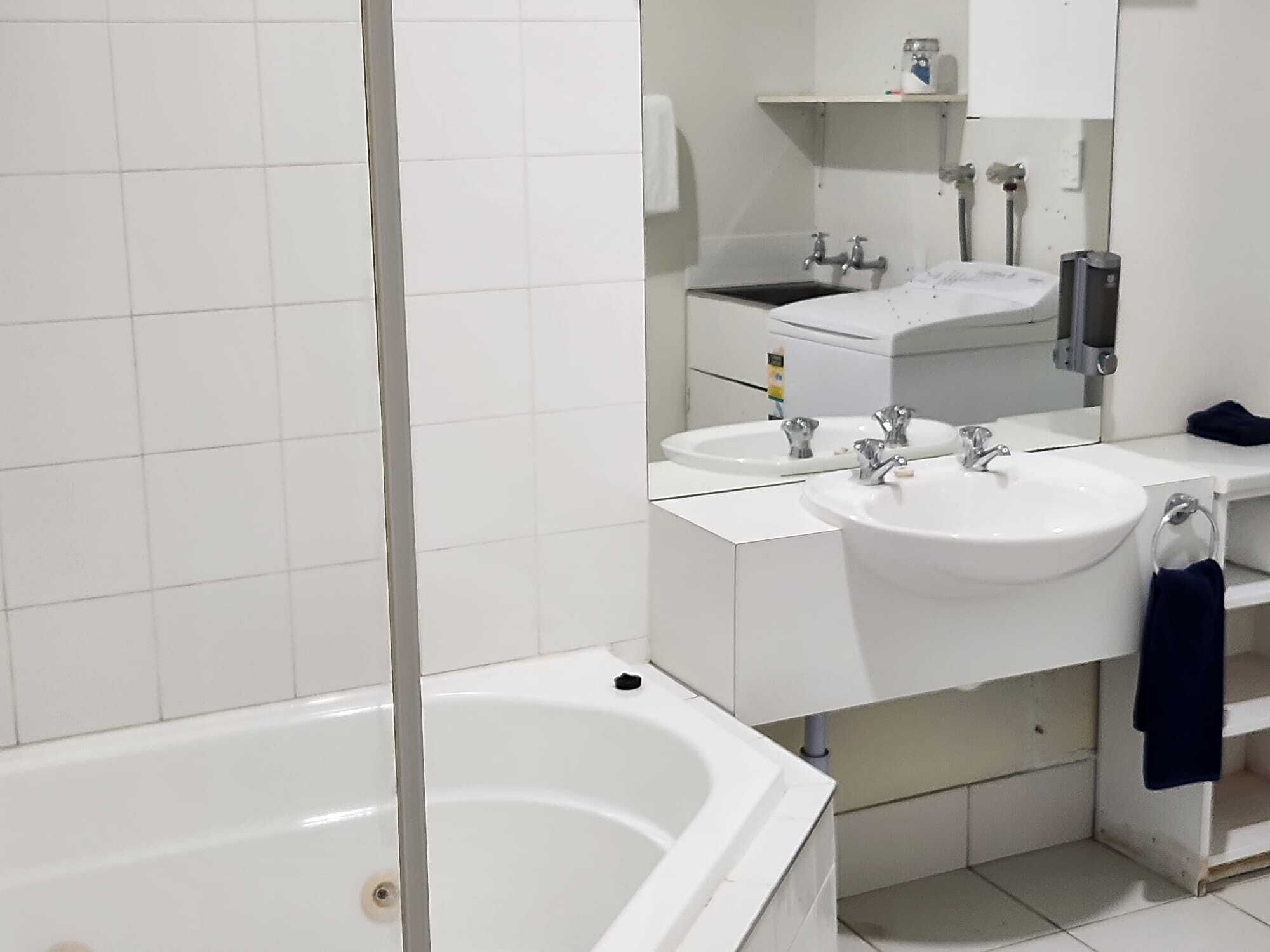 Une salle de bain moderne avec une baignoire, deux lavabos et un miroir.