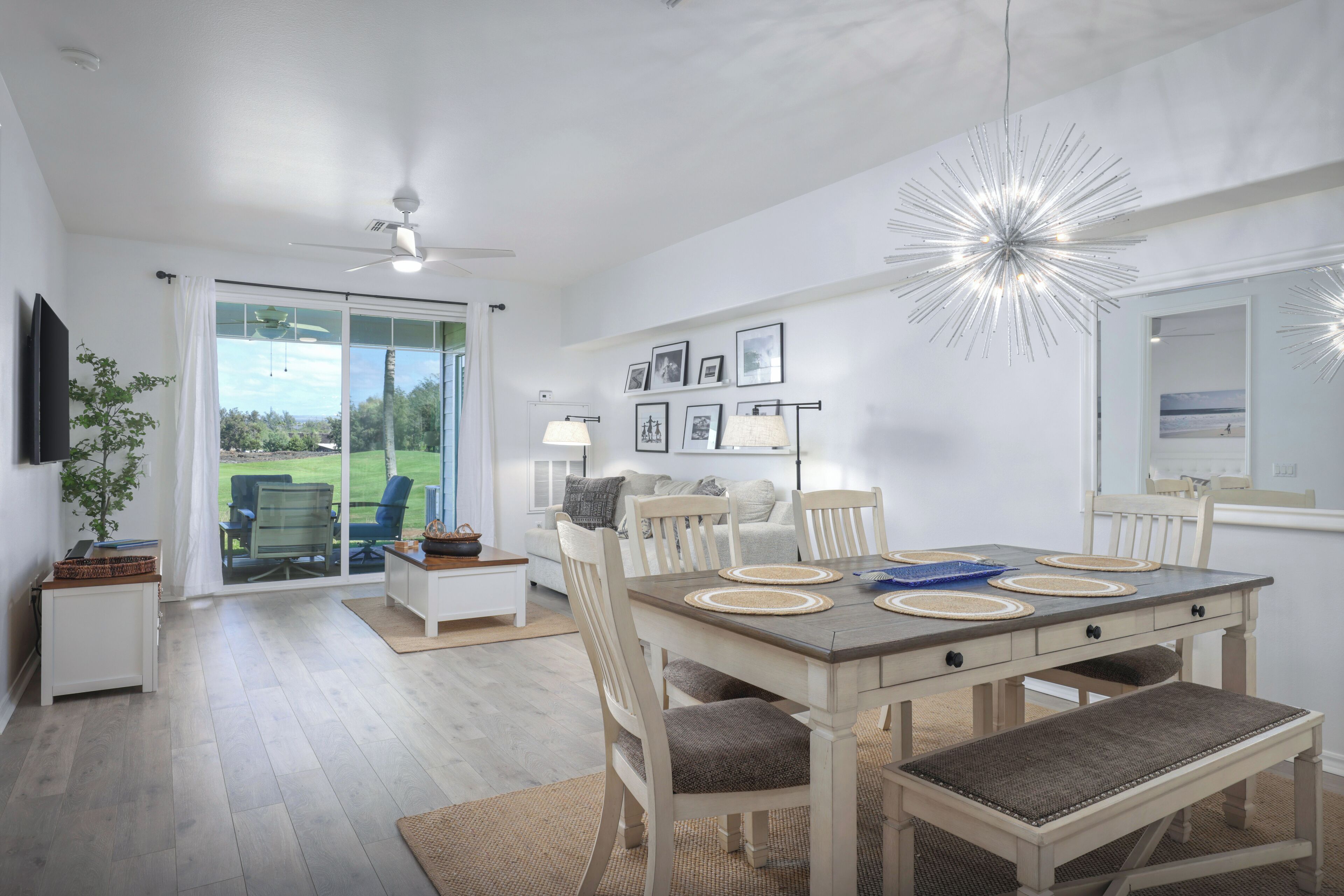 A dining area with a large table, chairs, and a ceiling fan.