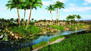 Un resort con fuente de agua, palmeras y un edificio con varios balcones.
