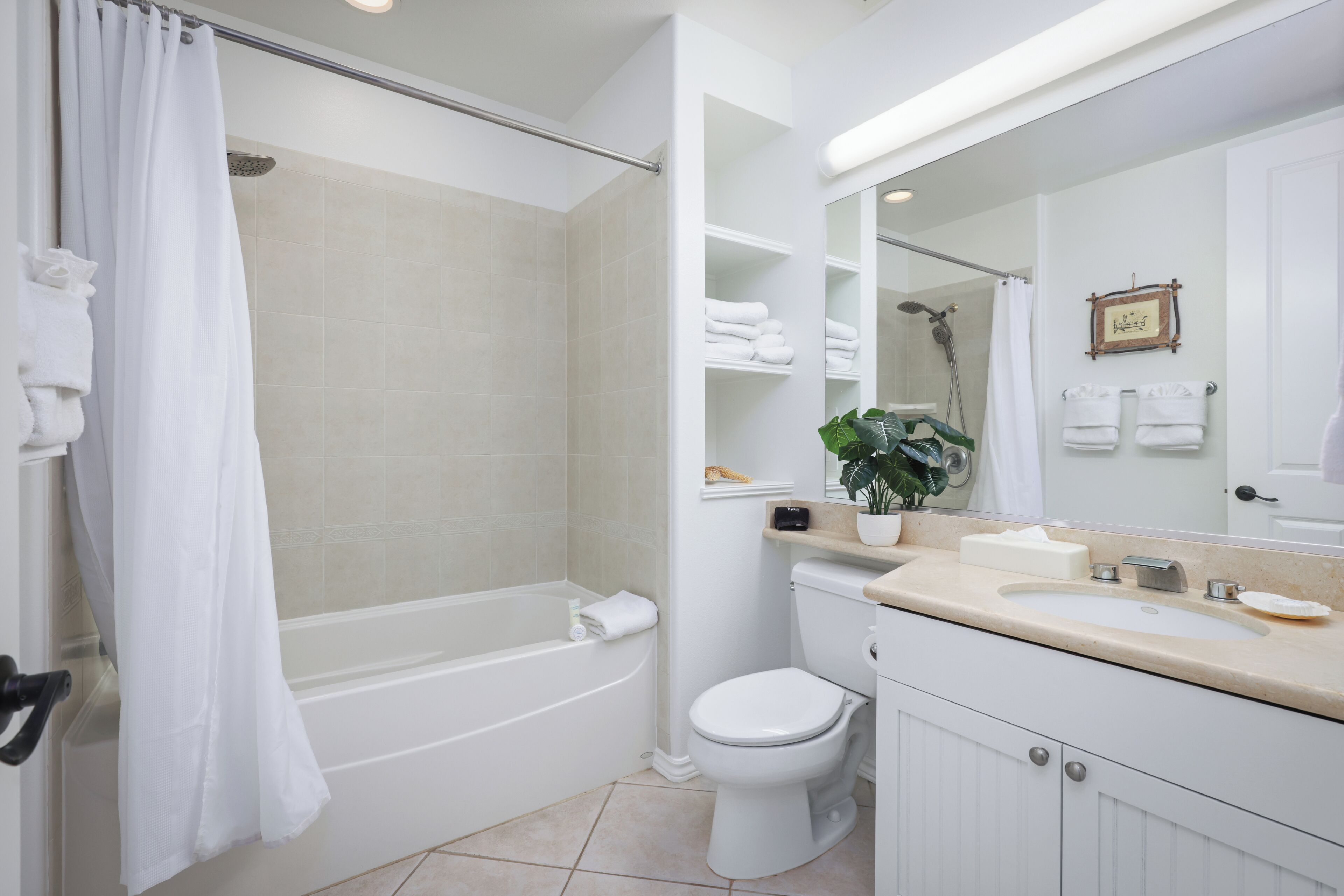 A modern bathroom with a bathtub, toilet, and sink.