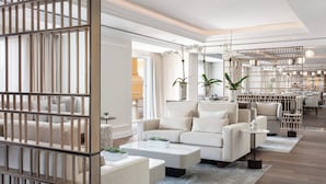 A modern living room with a sofa set, coffee table, and decorative plants. - The Ritz-Carlton Orlando, Grande Lakes (Orlando)