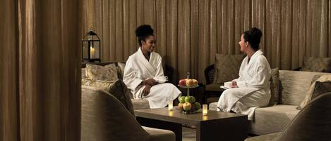 A room with two sofas, a coffee table, and a fruit tray.