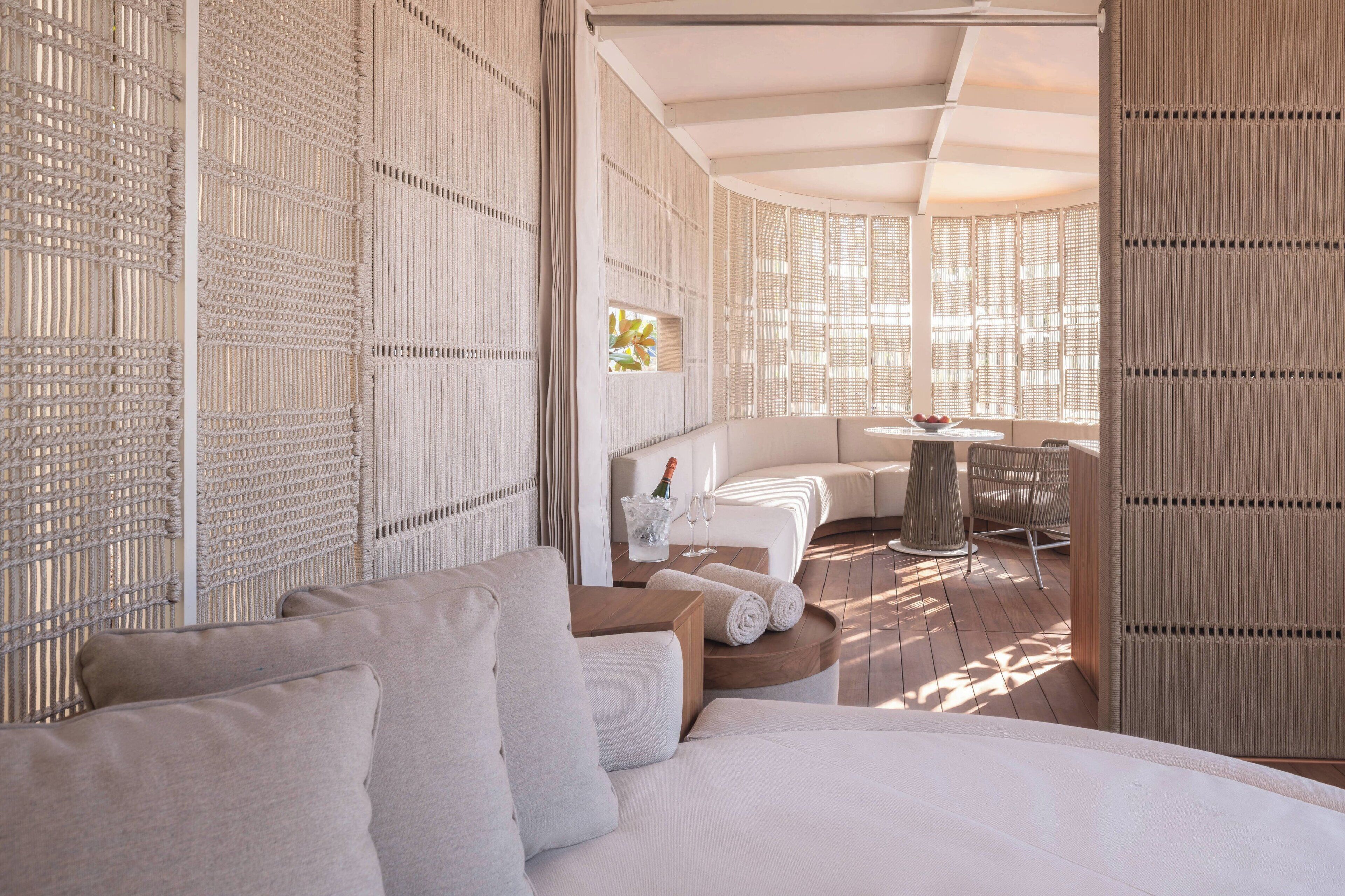 Una habitación de hotel moderna con una cama grande, un rincón de descanso con una mesa y sillas, y vistas al exterior.