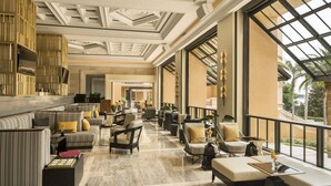 A spacious lobby with a high ceiling, large windows, and a variety of seating arrangements including sofas and armchairs.