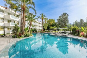 Una piscina al aire libre de temporada, sombrillas