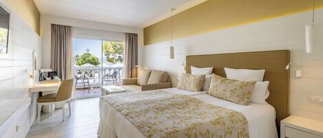 Une chambre d’hôtel avec un grand lit, un bureau, une chaise et un balcon avec des meubles d’extérieur.