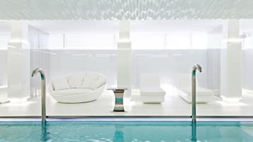 Relax by the rectangular pool surrounded by lounge chairs and a unique ceiling design.