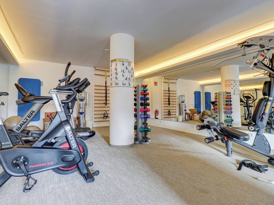 A gym with stationary bikes, weight machines, and various exercise equipment.