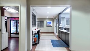 Ein Hotelgang mit einer Küchenzeile, einem Kühlschrank und einer Kaffeemaschine.