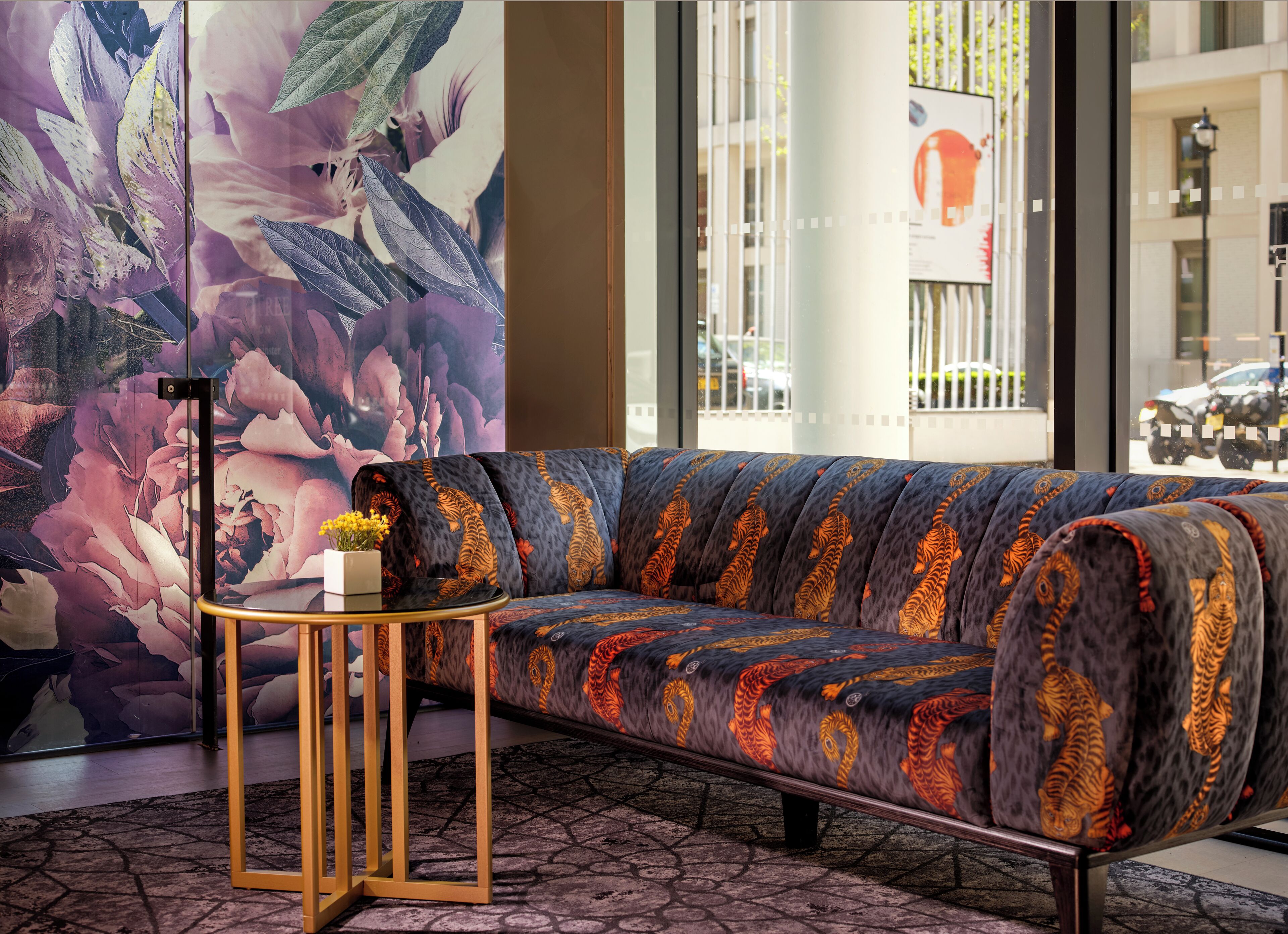 Un salon moderne avec un canapé, une petite table ronde et un grand tableau abstrait.