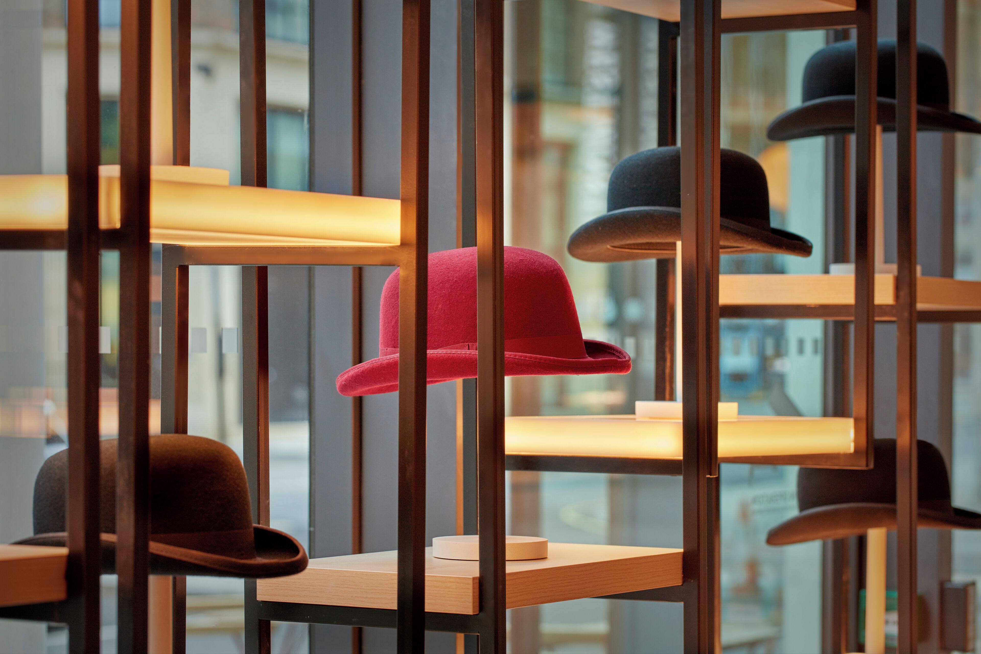 A display of hats on shelves with a cityscape view in the background.