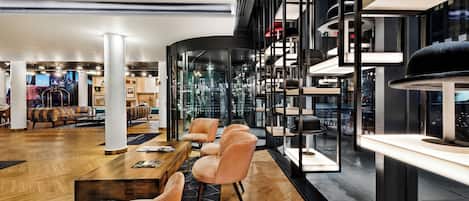 A modern interior with a wooden floor, seating area, and glass walls.