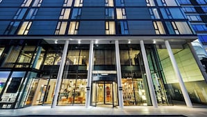 A modern building with large glass windows and a prominent entrance.