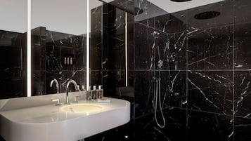 A modern bathroom with a white sink, chrome faucet, and a handheld showerhead.