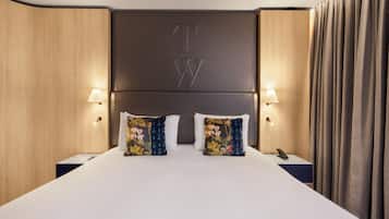 Ein Hotelzimmer mit einem großen Bett, zwei Nachttischen, einer Lampe und einem Vorhang.