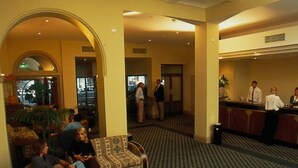 A lobby with a reception desk, seating area, and a patterned carpet. - Criterion Hotel Perth (Perth)