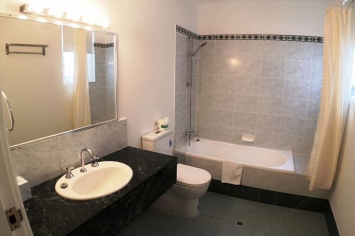 A bathroom with a sink, toilet, and bathtub.
