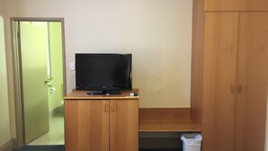A room with a wooden cabinet, a television on top, a trash bin, and a wardrobe. - Criterion Hotel Perth (Perth)
