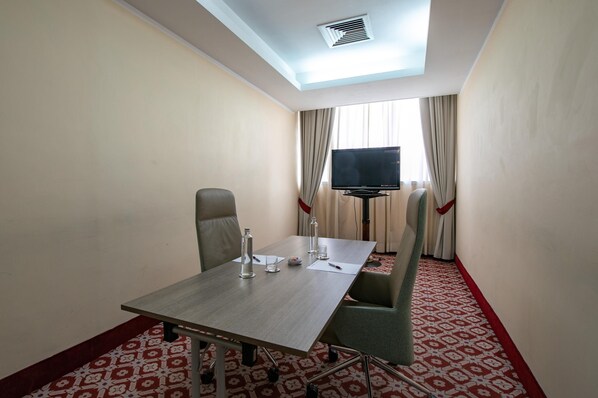 A conference room with a table, chairs, a television, and a patterned carpet. - Etrusco Arezzo Hotel, Sure Hotel Collection by Best Western (Arezzo)