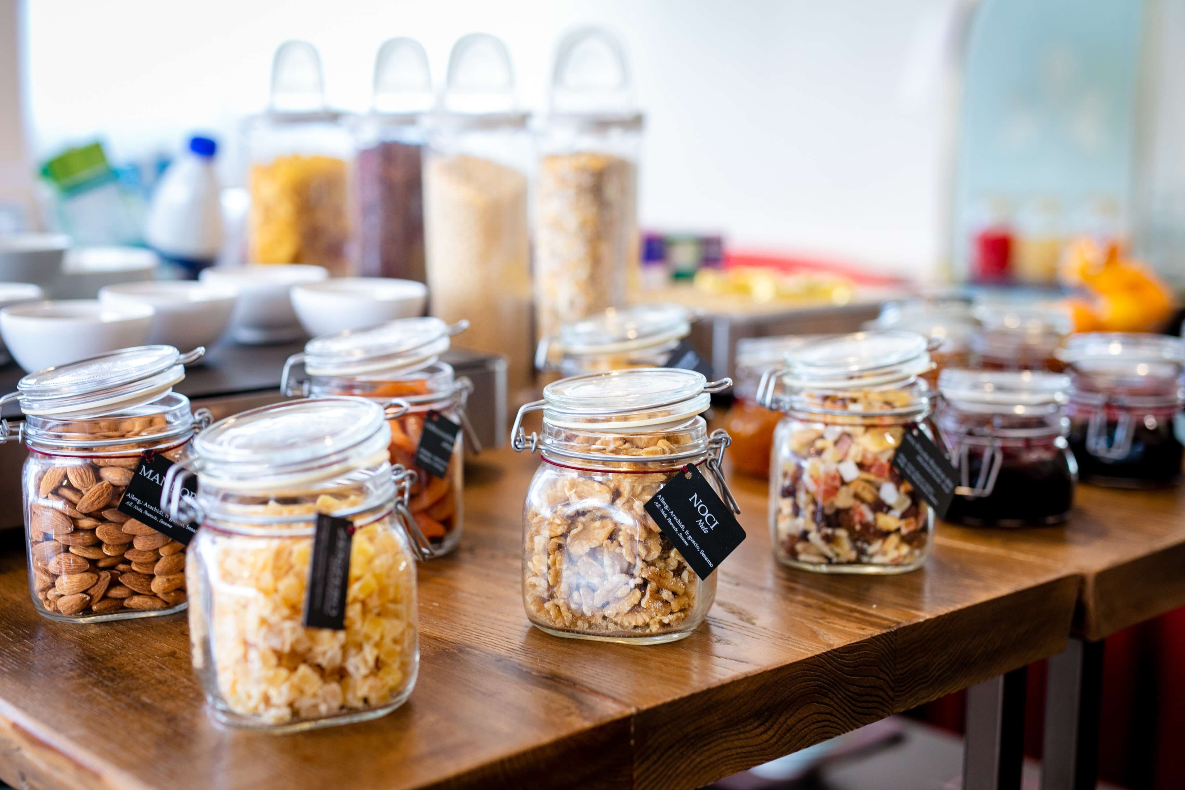 Una mesa de madera con varios frascos de vidrio que contienen diferentes alimentos.