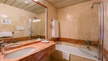 Un bagno con uno specchio grande, due lavandini, una vasca e una doccia.