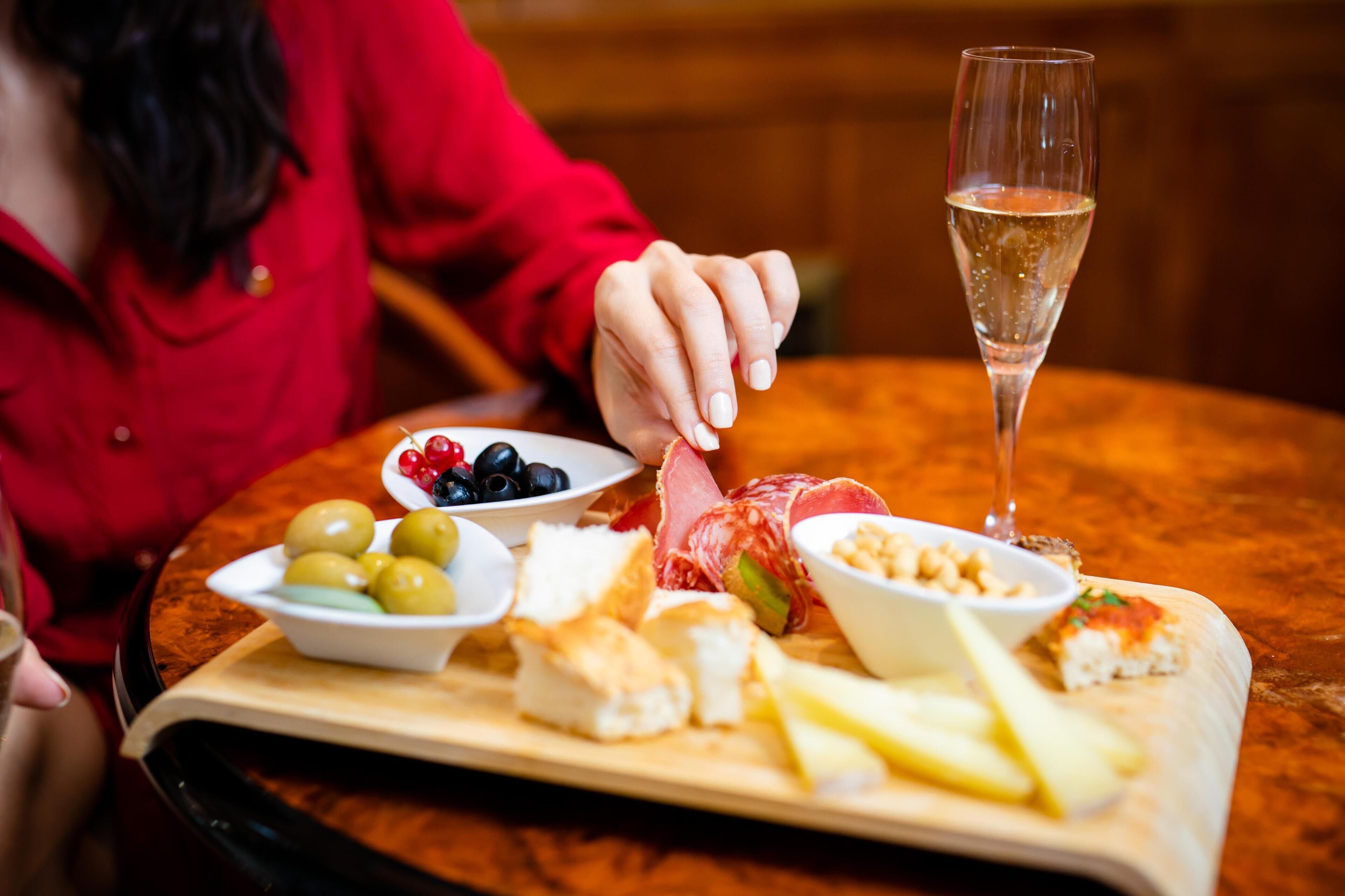 A table with a variety of food items and a glass of champagne.