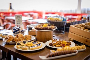 A buffet table with various pastries, including croissants, a cake, and fruit slices. - Etrusco Arezzo Hotel, Sure Hotel Collection by Best Western (Arezzo)