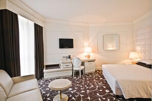 A hotel room with a bed, a desk with a chair, a television, and a small round table. - Etrusco Arezzo Hotel, Sure Hotel Collection by Best Western (Arezzo)