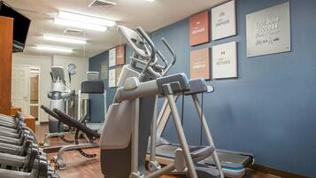 A fitness center with treadmills, ellipticals, and dumbbells.