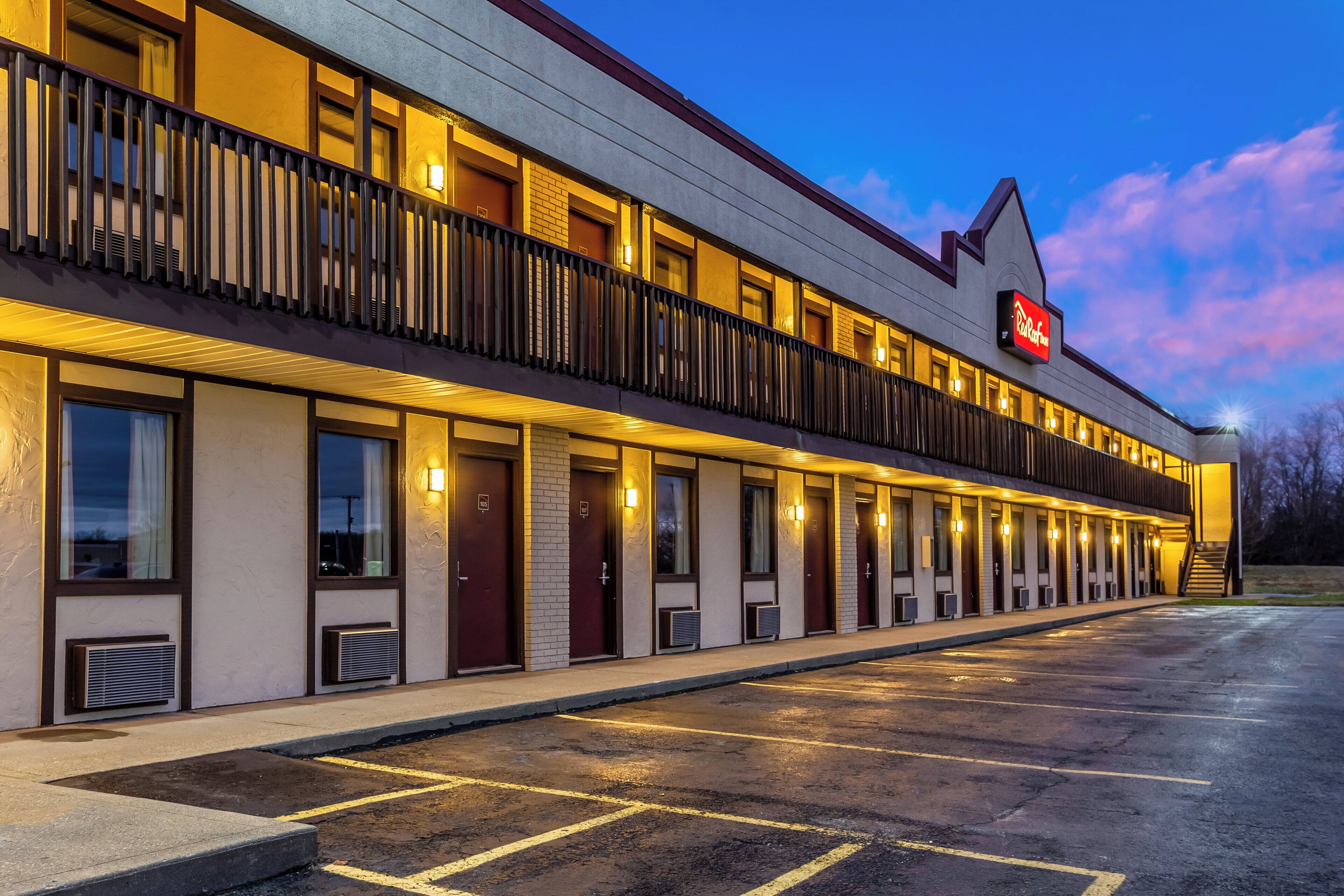 Un hotel con estructura de dos pisos, varias habitaciones y un área exterior cubierta.
