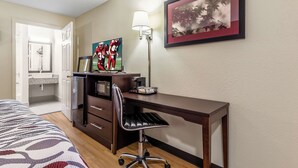 A hotel room with a bed, a desk, a chair, a microwave, a coffee maker, and a framed picture on the wall. - Red Roof Inn Scottsburg (Scottsburg)
