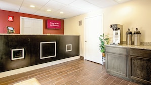A reception area with a red wall, a white door, and a sign indicating free Wi-Fi in all rooms. - Red Roof Inn Scottsburg (Scottsburg)