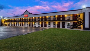 A Red Roof Inn with a two-story structure, a covered parking area, and a well-maintained lawn. - Red Roof Inn Scottsburg (Scottsburg)
