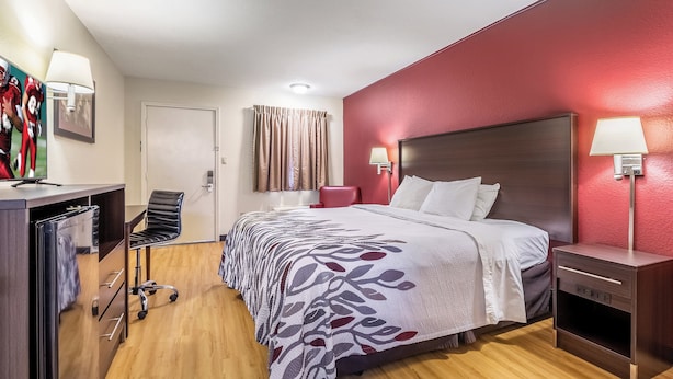 A hotel room with a bed, a desk, a chair, and a wardrobe. - Red Roof Inn Scottsburg (Scottsburg)