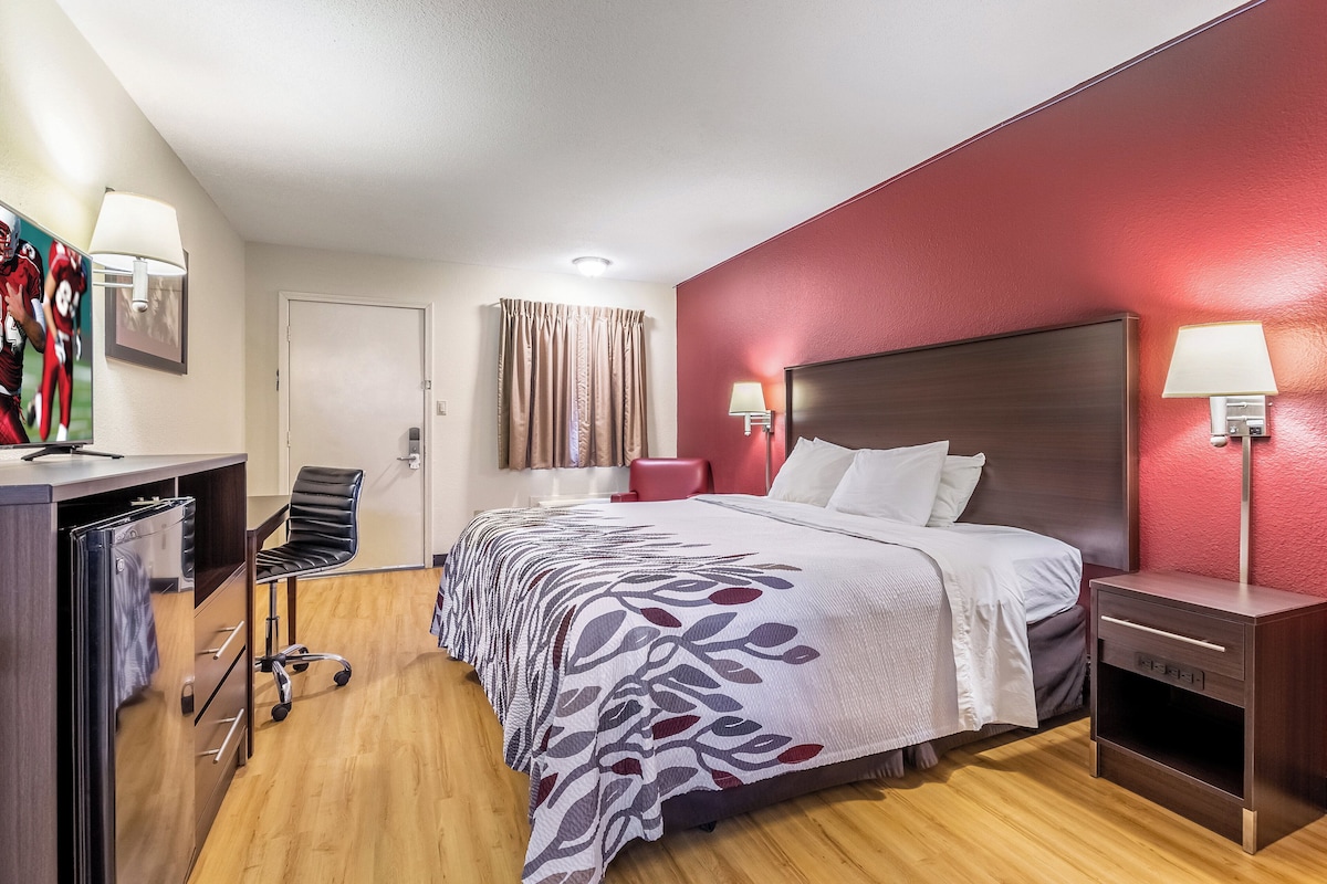 Une chambre d’hôtel comprenant un lit, un bureau, une chaise et une armoire.