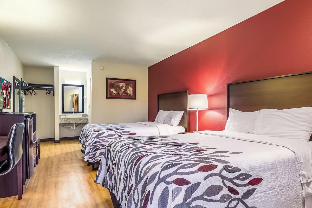 Une chambre d’hôtel avec deux lits, une salle de bain et un coin salon.
