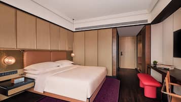 Habitació d'hotel moderna amb un llit gran, un escriptori, una panxa vermella i una televisió.