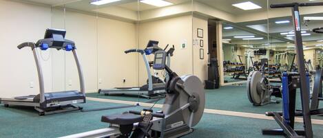 A gym with treadmills, an elliptical, and weight machines.