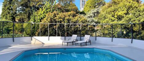 Een seizoensgebonden buitenzwembad en parasols bij het zwembad