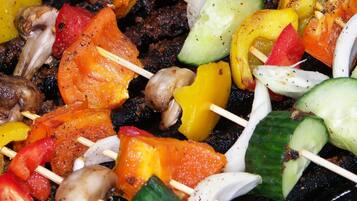 A close-up of colorful vegetable and meat skewers on a grill.