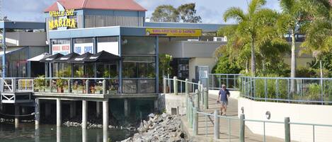 A waterfront restaurant with a sign for 'Whale Bay Marina' and 'Breakfast & Lunch'.