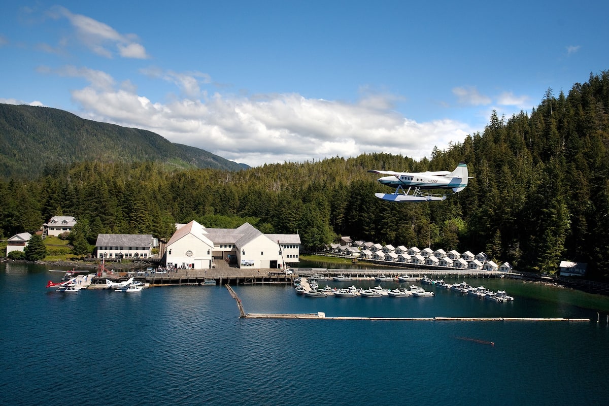 A waterfront property with a dock, boats, and a building with a white facade.