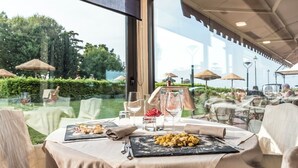 Un espace extérieur aménagé pour les repas, avec des tables, des chaises et des parasols.