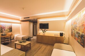 Relax in a cozy seating area with a sofa and table, flat-screen TV, and coffee machine.