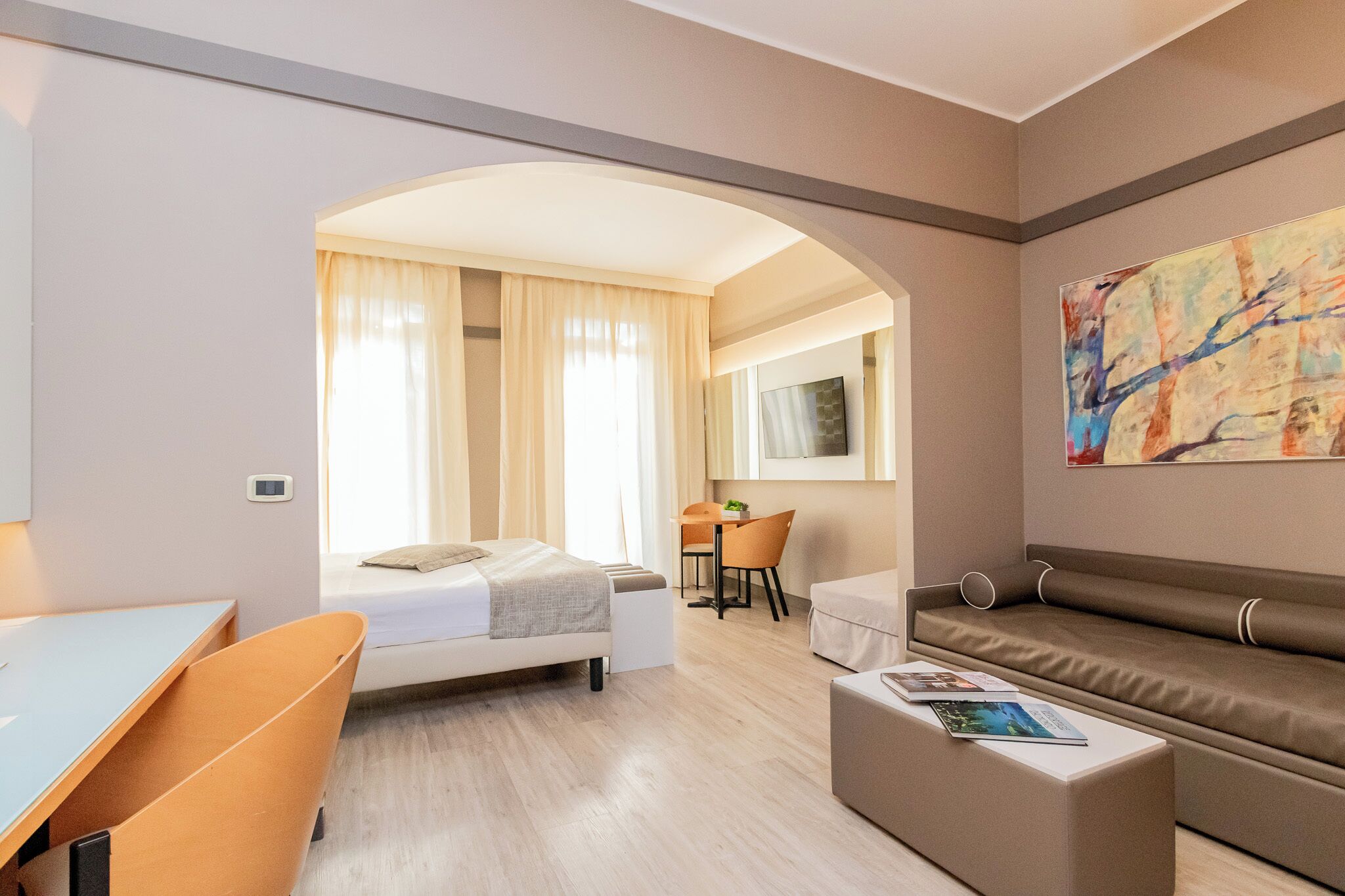 Une chambre d’hôtel moderne équipée d’un lit, d’un bureau, d’un canapé et d’un coin repas.