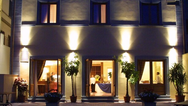 Een gebouw met meerdere open deuren en ramen, wat doet denken aan een hotel of restaurant met een open indeling.